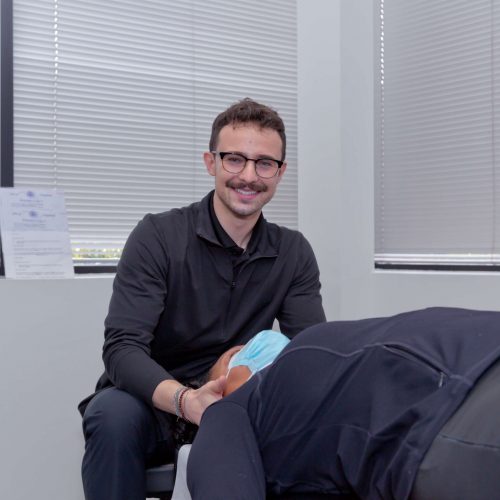Home 10 Dr. Connor Reed giving patient neck pain treatment